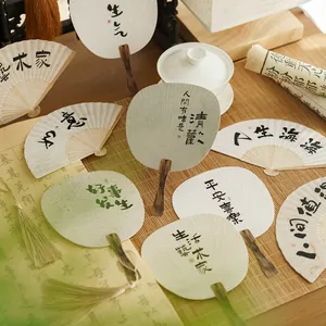 Traditional Chinese hand fans set with calligraphy on bamboo mats and scroll backdrop