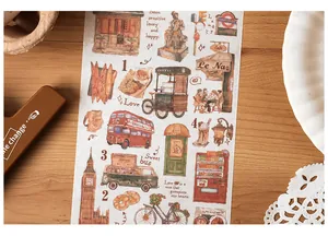 Detail of retro London travel stickers with Big Ben and red bus on washi paper