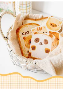 Detail of cute bread-shaped postcards with panda and cat illustrations in a basket