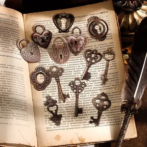 Set vintage di lucchetti a cuore e chiavi su un vecchio libro con penna d'oca