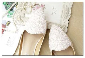 Vista de detalle de bailarinas beige de punta con adornos florales de lentejuelas elegantes