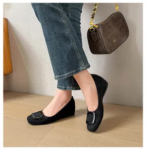 Close-up of elegant black suede flat shoes with square buckle worn for office commuting
