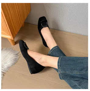 Detail view of black suede flat shoes with a large square buckle for commuting
