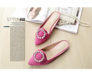 Macro detail of rose pink suede mule with large sparkling rhinestone buckle and inner sole