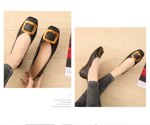 Détail de ballerines noires à bout carré avec une grande boucle dorée élégante