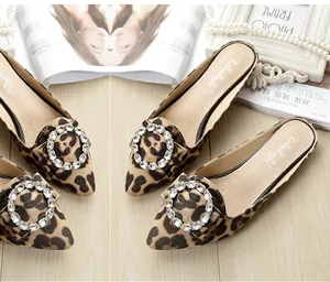 Macro shot of leopard print pointed-toe mule flats with sparkling rhinestone buckle