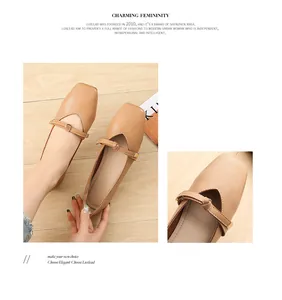 Close-up of khaki square toe flat shoes with knot detail and polished buckle on wood background