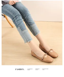 Detail of square toe ballet flat with strap button and raw edge denim jeans on chair