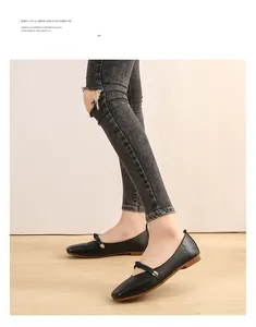 Close-up of black square toe Mary Jane flats with matte finish and gold buckle strap
