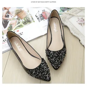 Primo piano di ballerine a punta nere con eleganti perline, paillettes e strass brillanti