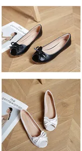 Dettaglio di ballerine spuntate in pelle opaca con doppio fiocco nero e beige
