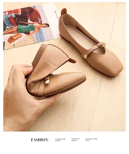 Macro shot of flexible square-toe ballet flats showing soft foldable leather and bow detail