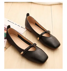 Top view of black square-toe flats featuring a decorative gold buckle and vintage design