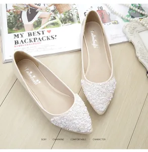 Dettaglio di ballerine a punta beige con paillettes glitterate e decori di perle