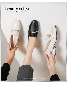 Detail of square toe loafers with crystal horsebit buckle on block heels in black and beige