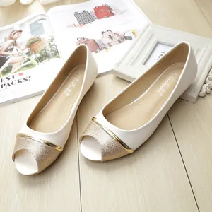 Elegante beige Peeptoe-Ballerinas mit goldenen Metalldetails auf hellem Holzboden