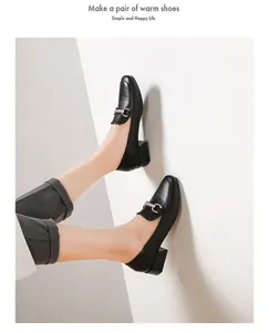 Close-up of black block heel loafers featuring matte leather and silver chain detail