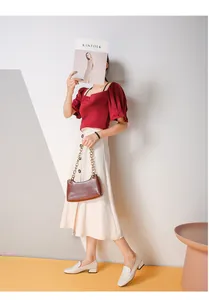 Mocasines blancos combinados con un top rojo de mangas abullonadas y falda midi blanca