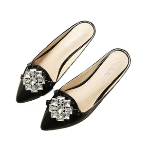 Elegant black pointed toe flat mule with sparkling square crystal buckle on shiny patent leather
