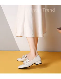 Vue détaillée des mocassins crème avec nœud décoratif et talon bloc très stable