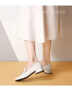 Detail shot of cream leather loafers with metal horsebit buckle and chunky square heel