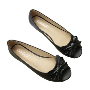 Eleganti ballerine nere spuntate con fiocco decorativo su sfondo bianco pulito