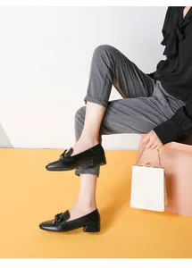 Mocassins en cuir noir pour femmes avec nœud portés par un mannequin en style business chic