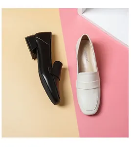 Vista superior de elegantes mocasines de punta cuadrada en negro y beige de piel lisa