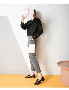 Mocassins noirs à nœud avec pantalon gris et sac à main blanc à chaîne métallique