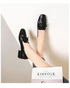 Détail du mocassin noir pour femme avec talon bloc, nœud élégant et boucle dorée