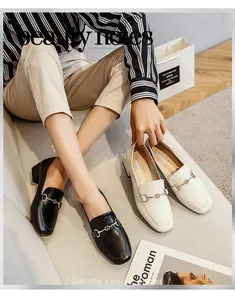 Détail de mocassins à bout carré avec boucles mors de cheval en noir et beige