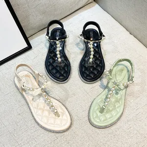 Flat lay of women's T-strap sandals with pearls and bows in black, beige, and green colors