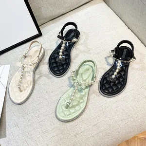 Flat thong sandals for women with pearls and bow details in black, white, and green