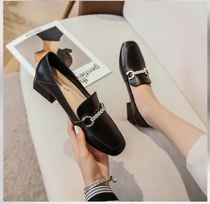 Detailed close-up of a black square-toe leather loafer featuring a silver metal chain buckle