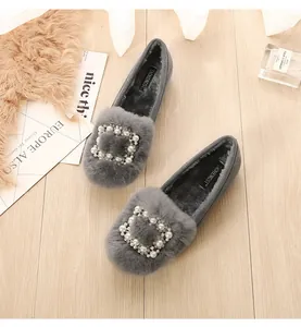 Macro view of grey fur loafers with luxury pearl buckle and warm fleece lining