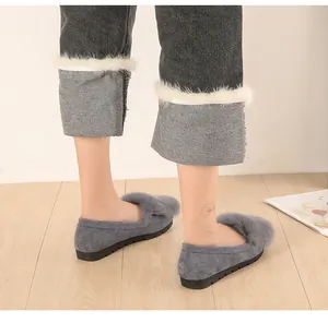 Detail of grey suede loafers with fluffy rabbit fur trim and non-slip soles on a model