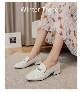 Detail shot of off-white square toe loafers with metal buckle on a cozy background