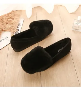 Detailed top view of black faux fur loafers with soft plush lining on wooden floor