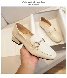 Detail of off-white loafers featuring square toe, low block heel and sparkling metal buckle
