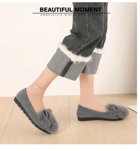 Detalle de mocasines grises de invierno para mujer con orejas de conejo de felpa y suela