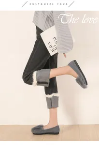 Detalle de mocasines de gamuza gris con pompones de piel y estilo invernal coordinado