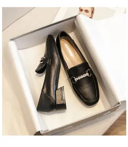 Macro shot of black square-toe loafers with rhinestone metal buckle in a luxury shoebox