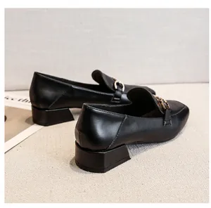 Close-up of black leather square toe loafers with gold chain and low block heel