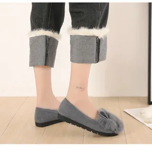 Detalle de mocasín de invierno gris con pompón de piel de conejo y suela gruesa antideslizante