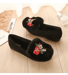 Détail de la broderie florale sur ballerines en daim noir fourrées avec peluche