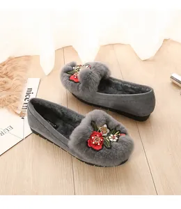 Détail de ballerines grises en daim avec broderie florale et doublure en fourrure
