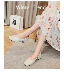 Close-up of stylish cream square-toe loafers with block heels and V-cut design