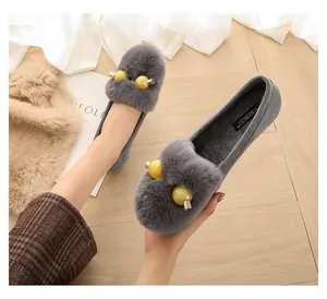 Dettaglio delle ballerine grigie in peluche con perline gialle e fodera interna morbida