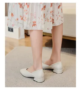 Detail view of cream pointed-toe loafers with low block heels and V-cut design