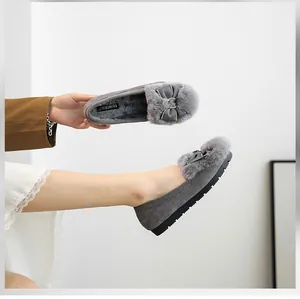 Detail showing the gray faux suede loafers with plush fur lining and elegant bow decoration